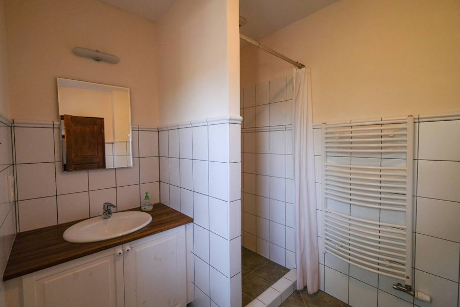 Koupelna se sprchou za závěsem, umyvadlem a sušákem ručníků